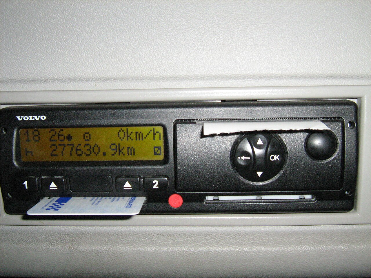 Driver card being put into a digital tachograph in a truck cab